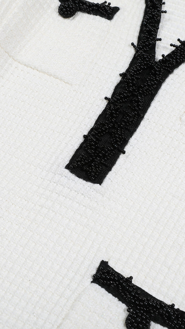 WEISSES MINIKLEID AUS STRICK MIT PERLENBESATZ