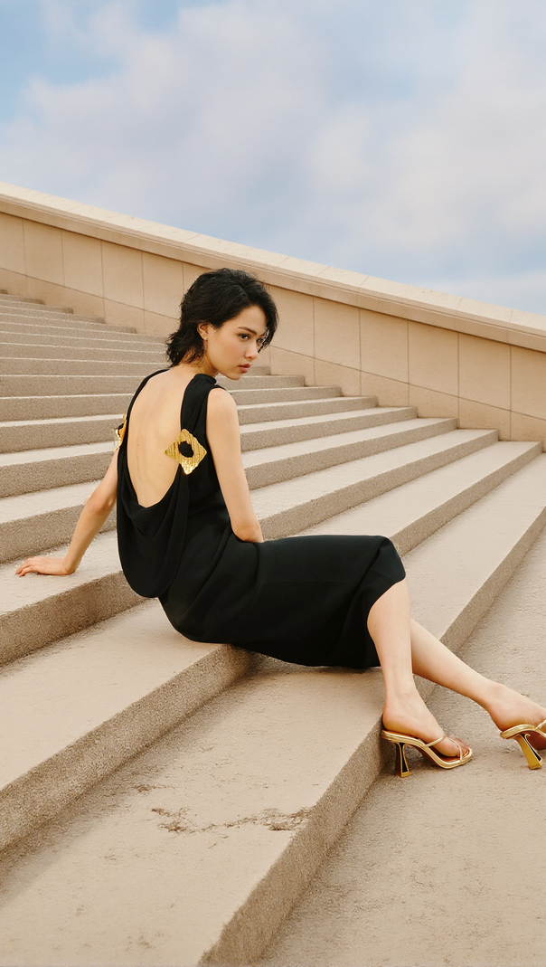 AIIZIE BLACK SLEEVELESS BACKLESS KNIT MIDI DRESS WITH TWO PLEATED GOLDEN EMBELLISHMENTS - product image
