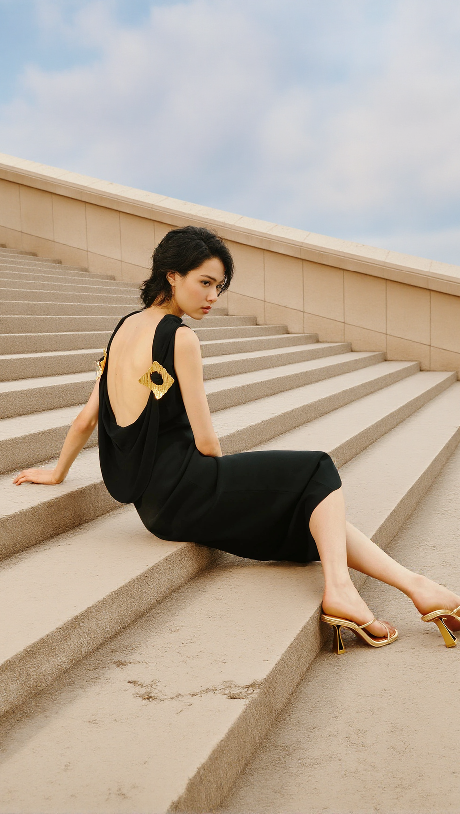 BLACK SLEEVELESS BACKLESS KNIT MIDI DRESS WITH TWO PLEATED GOLDEN EMBELLISHMENTS