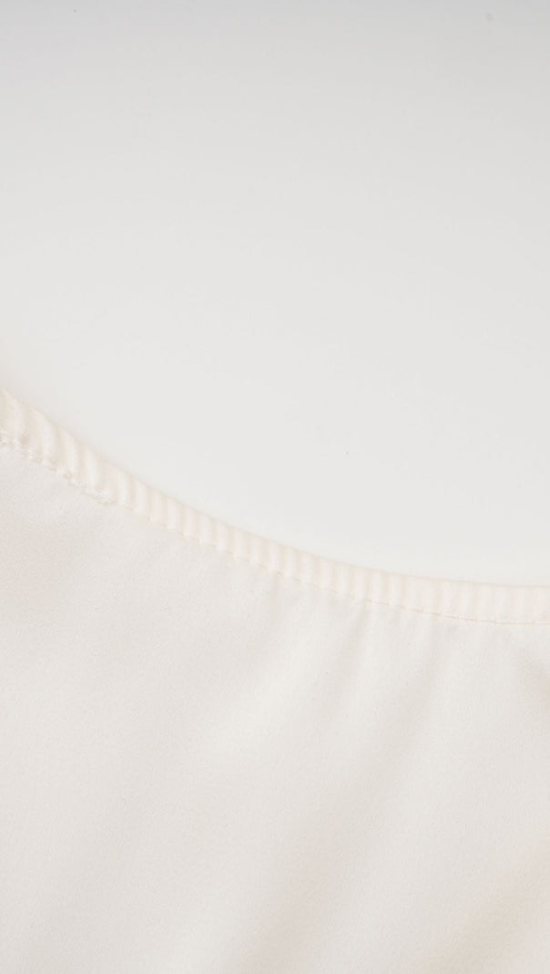 Nouria – Kurzes Oberteil mit Twist-Design und Kunstblumen in Weiß 