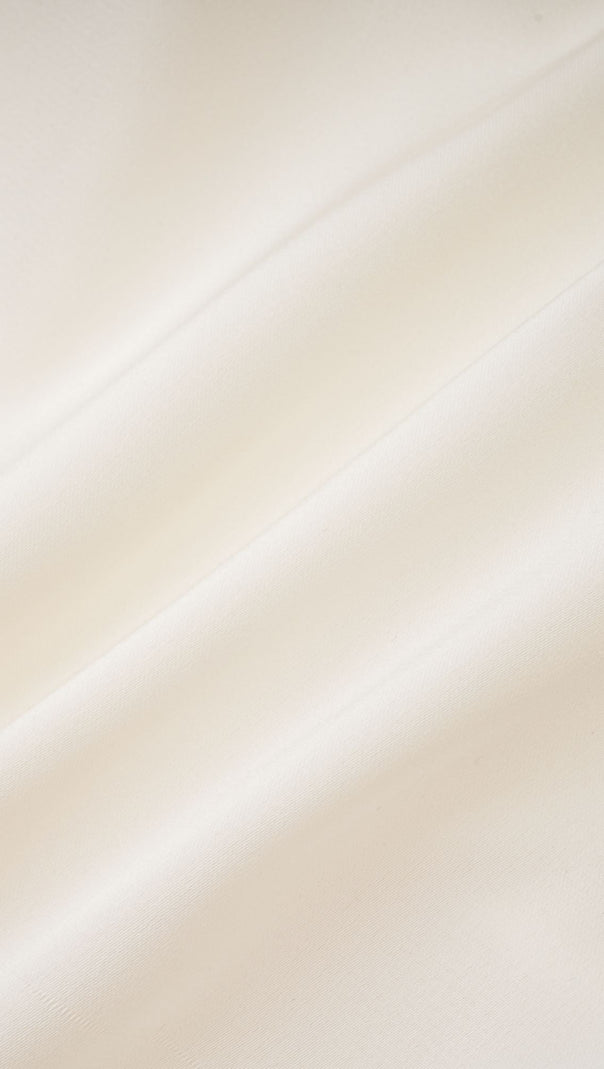 Nouria – Kurzes Oberteil mit Twist-Design und Kunstblumen in Weiß 