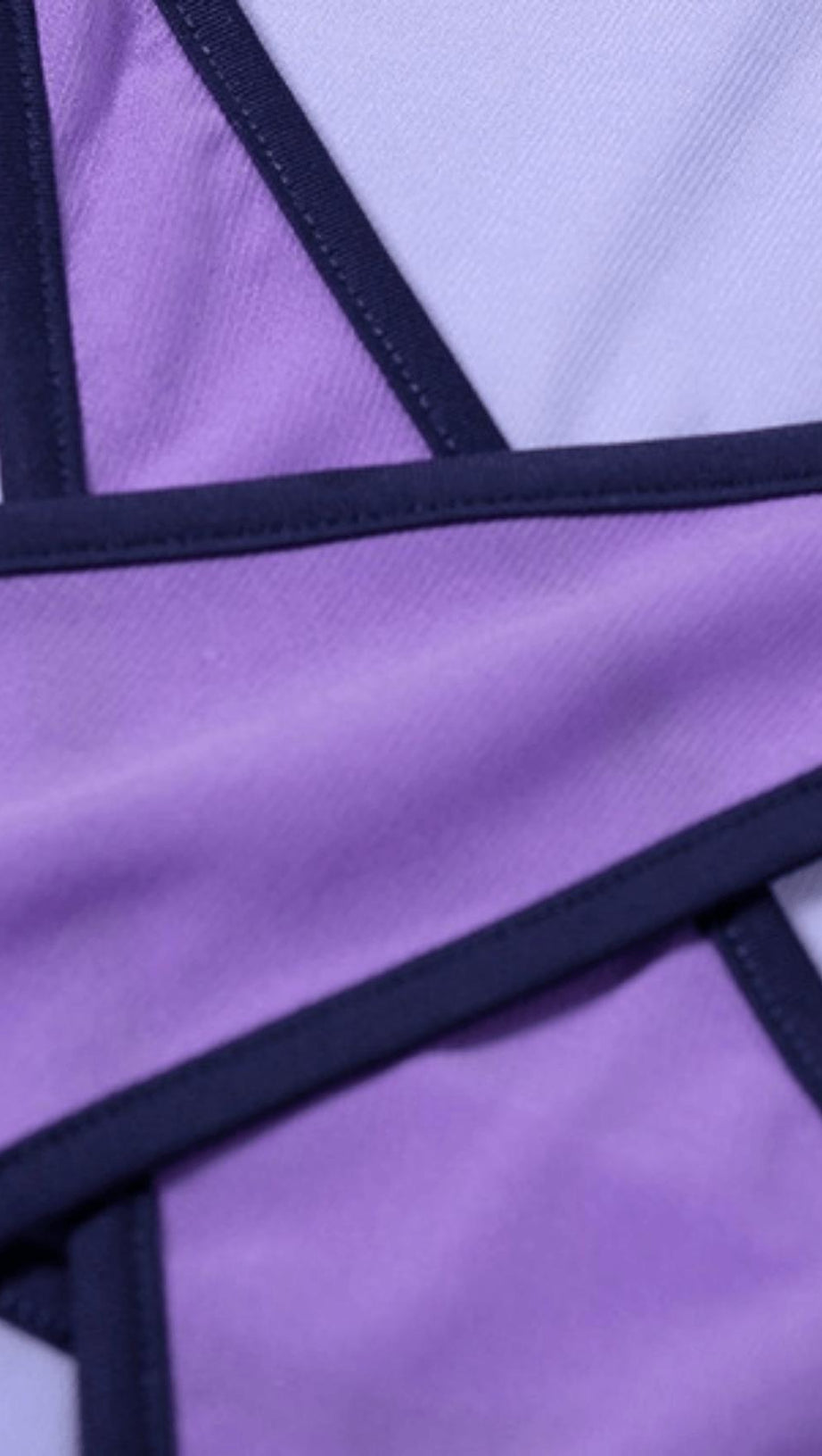 Lilafarbener Netz-Bodysuit mit Kontrasteinsätzen.