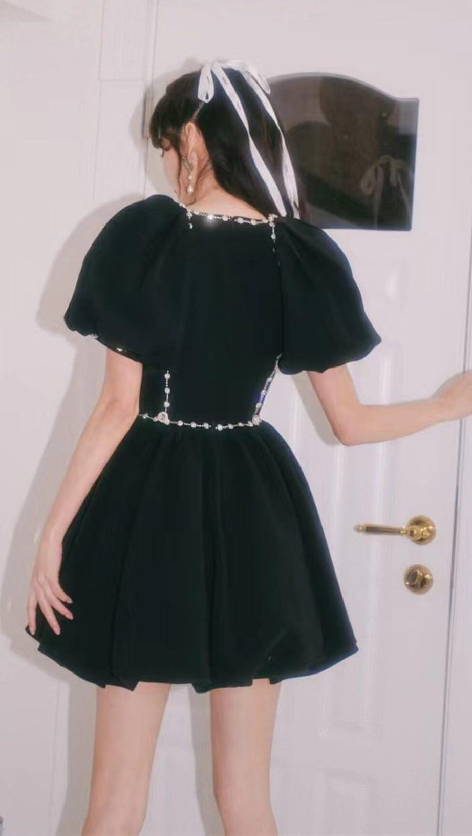 Schwarzes Puffkleid mit Rautenkettenschleife