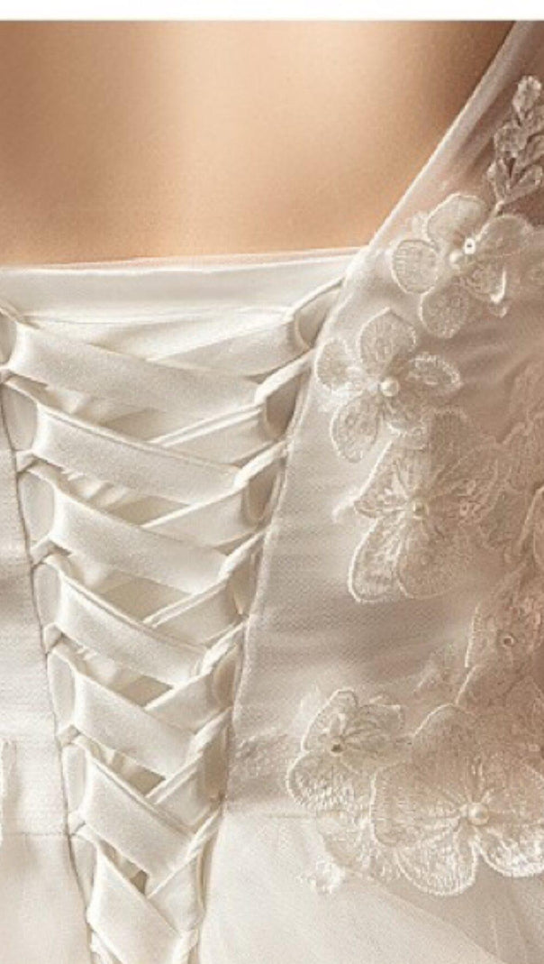 ABITO DA SPOSA CON FIORI TRIDIMENSIONALI E CODA A STRAPPO IN BIANCO